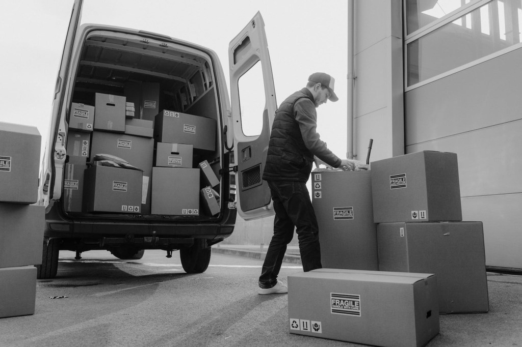 Delivery driver loading boxed into their van.